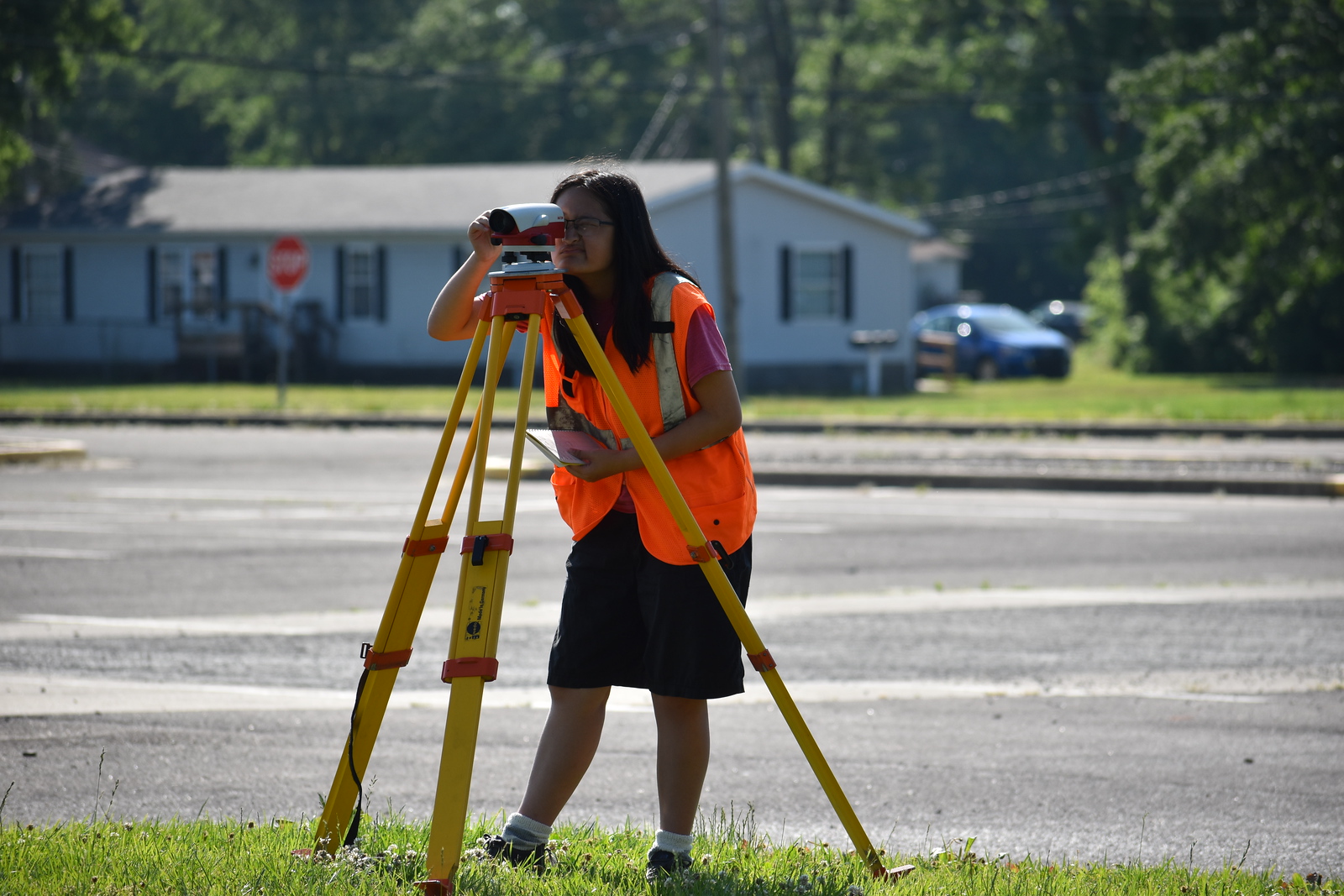 A student looking through the eyepiece of surveying equipment.
